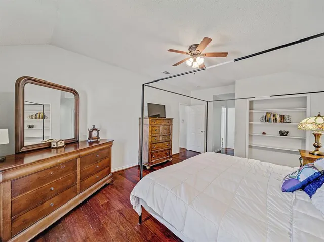 a bedroom with a bed and a dresser with mirror