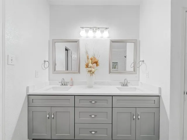 a bathroom with a double vanity sink and mirror