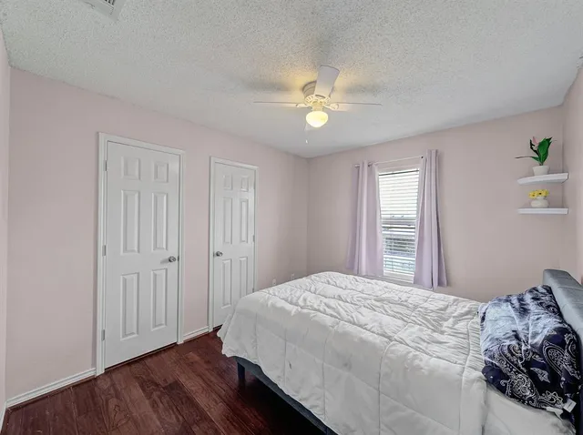 a bedroom with a bed and wooden floor