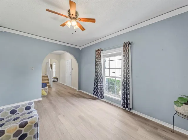 a view of a livingroom with wooden floor and a ceiling fan