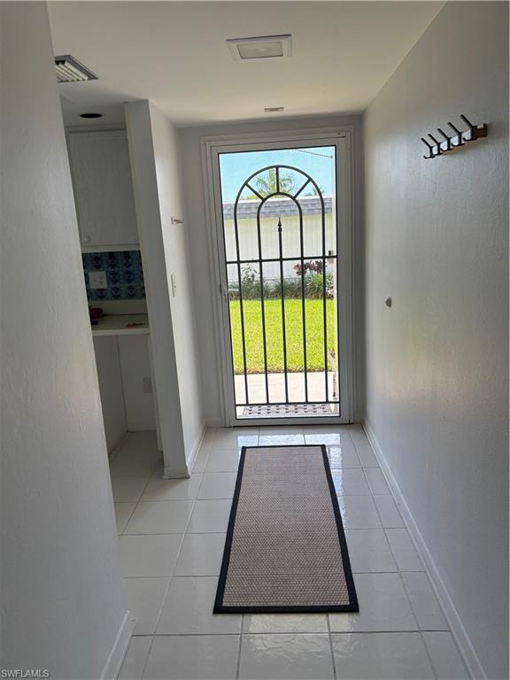 315 St Andrews Boulevard, Unit A2 Naples, FL 34113 - Photo 2 of 17 Entryway featuring a textured wall and tile patterned flooring