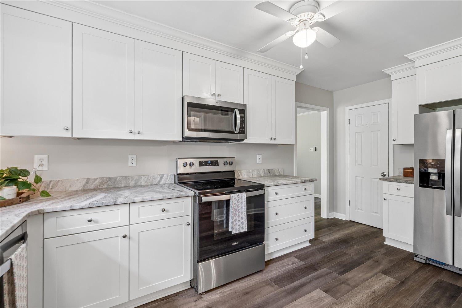 3351 Oak Road Bartlett, TN 38135 - Photo 14 of 30 Kitchen featuring white shaker-style cabinetry, stainless steel appliances, wood-finish flooring, and light-colored countertops