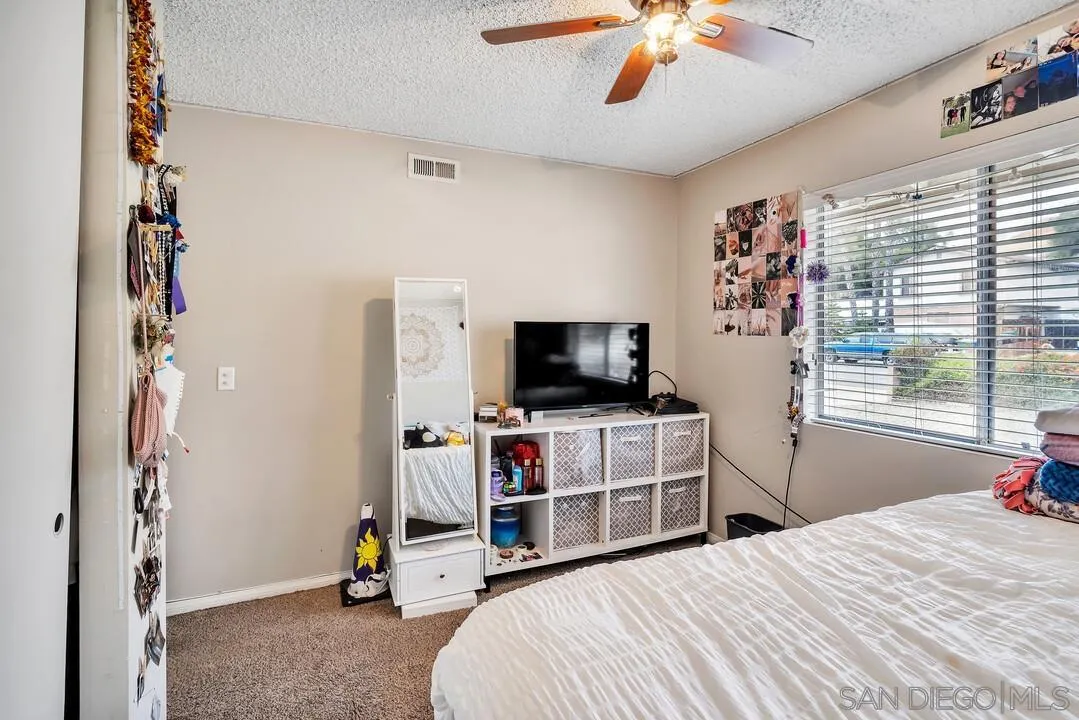 9677 Lutheran Way Santee, CA 92071 - Photo 23 of 33 a bedroom with a bed and a flat tv screen on the dresser