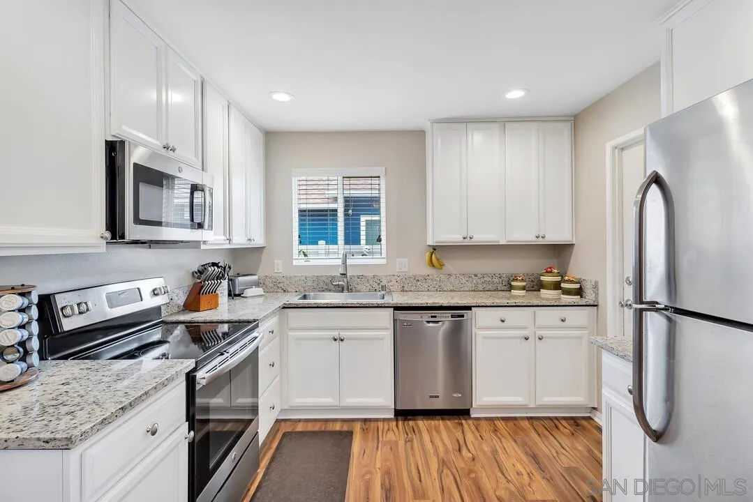 9677 Lutheran Way Santee, CA 92071 - Photo 7 of 33 a kitchen with stainless steel appliances granite countertop a sink stove and refrigerator