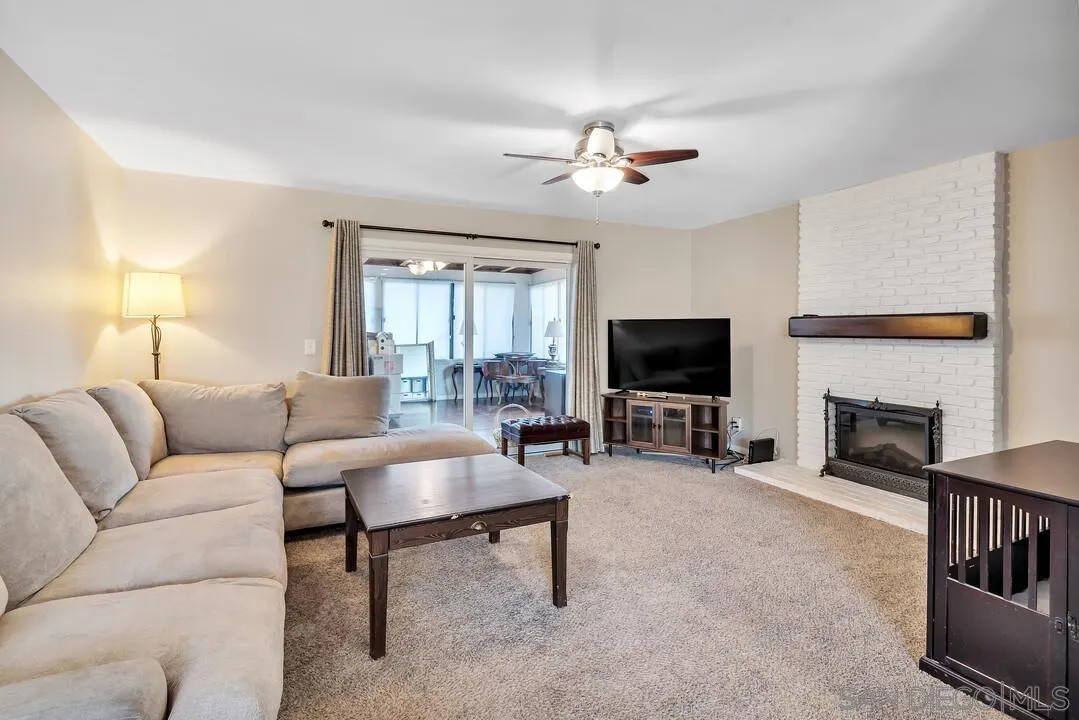 9677 Lutheran Way Santee, CA 92071 - Photo 9 of 33 a living room with furniture a flat screen tv and a fireplace