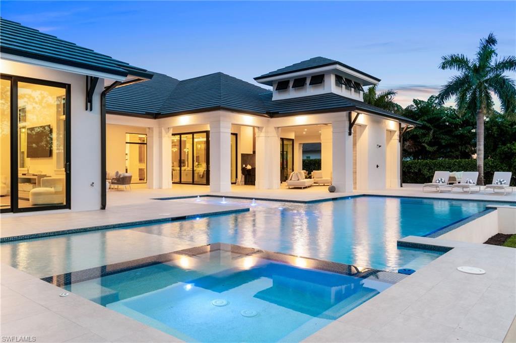 337 West Street Naples, FL 34108 - Photo 11 of 50 Pool at dusk with a patio area and an in ground hot tub