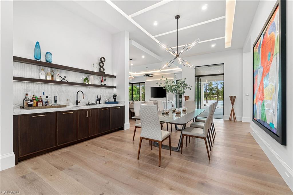 337 West Street Naples, FL 34108 - Photo 16 of 50 Dining area featuring light hardwood / wood-style flooring, sink, and a chandelier
