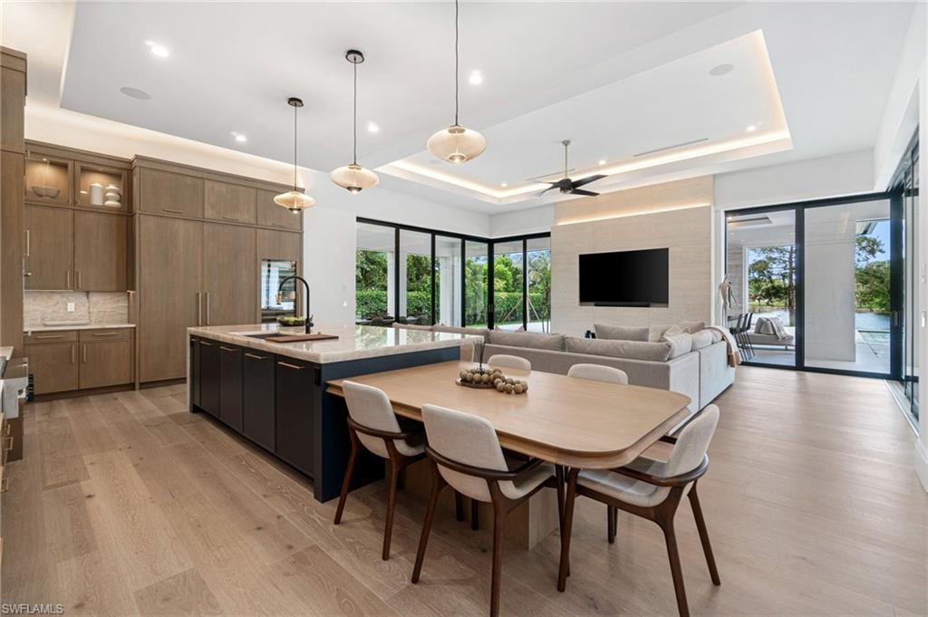 337 West Street Naples, FL 34108 - Photo 20 of 50 Dining area featuring a raised ceiling, light hardwood / wood-style flooring, sink, and plenty of natural light