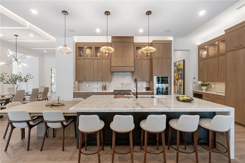 337 West Street Naples, FL 34108 - Photo 21 of 50 Kitchen with sink, decorative backsplash, and a large island