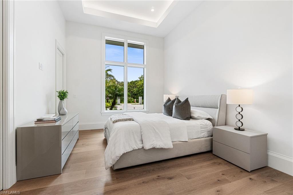 337 West Street Naples, FL 34108 - Photo 35 of 50 Bedroom featuring a raised ceiling and light wood-type flooring