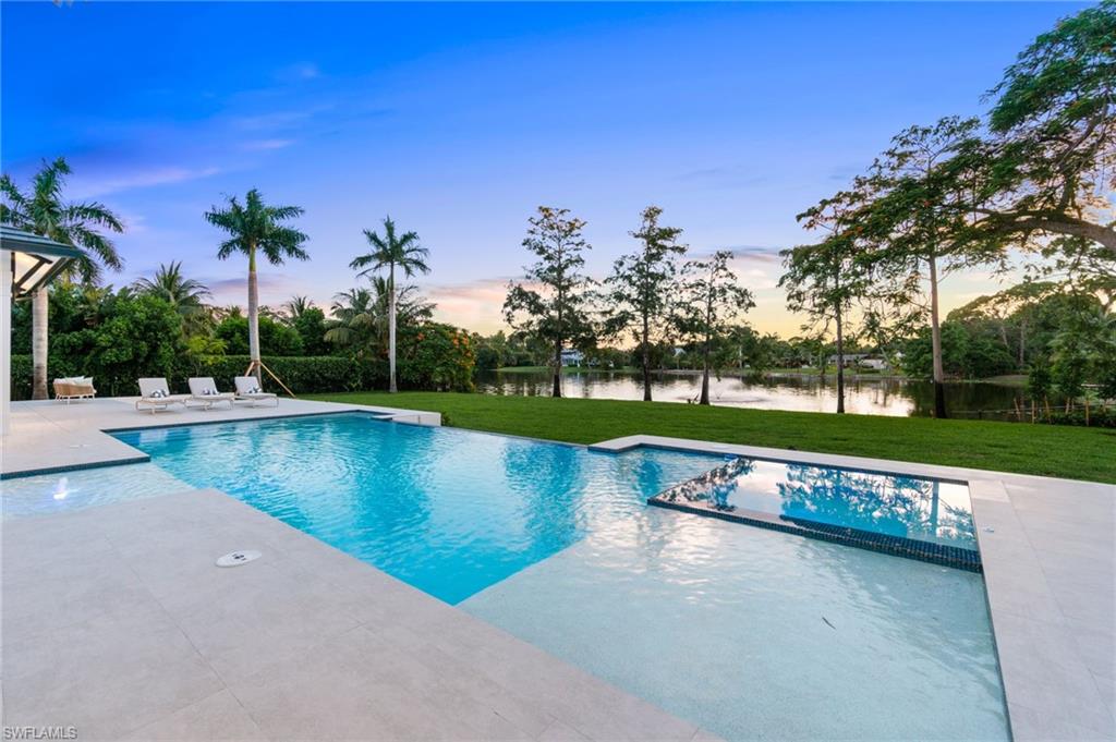 337 West Street Naples, FL 34108 - Photo 5 of 50 Pool at dusk featuring a patio and a lawn