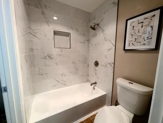 a bathroom with a toilet and a shower