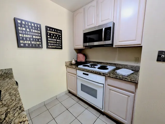 a kitchen with stainless steel appliances granite countertop a stove and a microwave