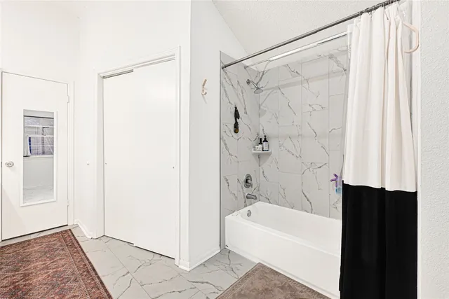 a bathroom with a bathtub a shower and a sink