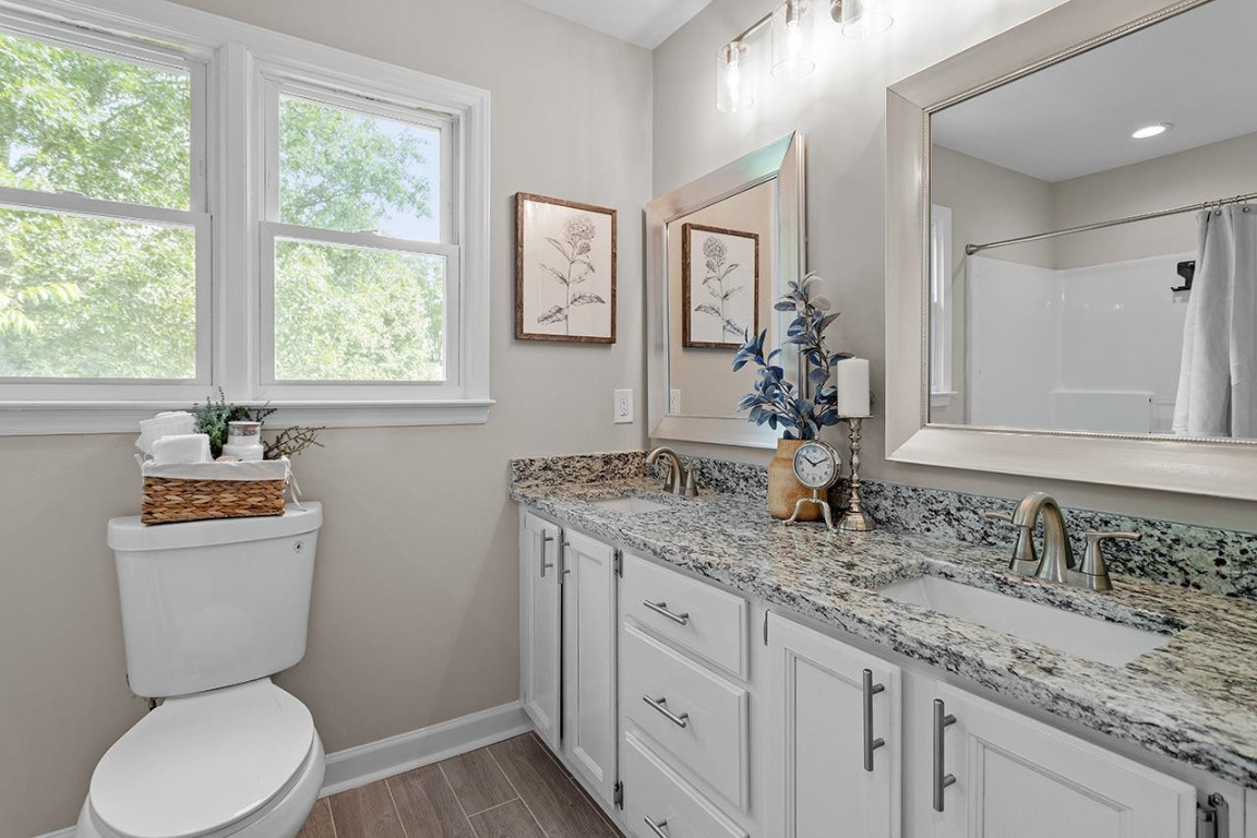 Undisclosed Address Wake Forest, NC 27587 - Photo 15 of 26 a bathroom with a granite countertop toilet sink and mirror with window