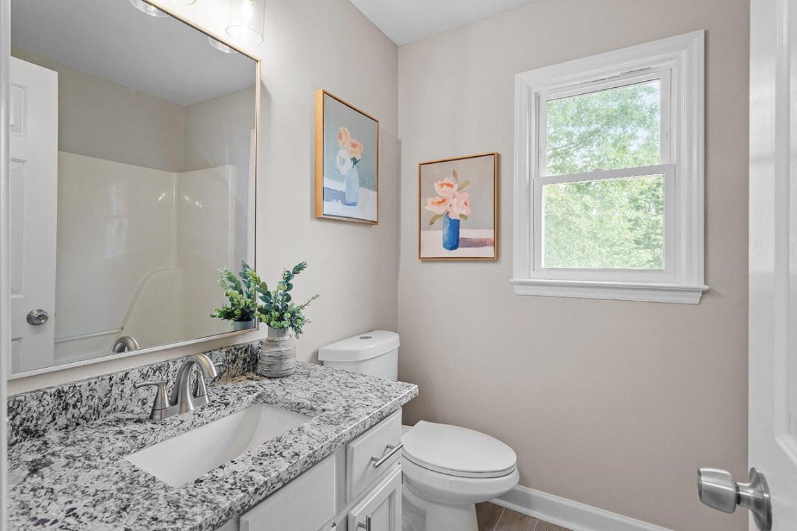 Undisclosed Address Wake Forest, NC 27587 - Photo 19 of 26 a bathroom with a granite countertop sink a mirror and a toilet