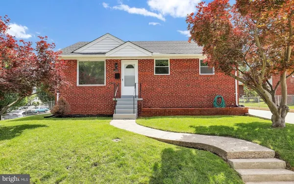 a front view of a house with a garden and yard
