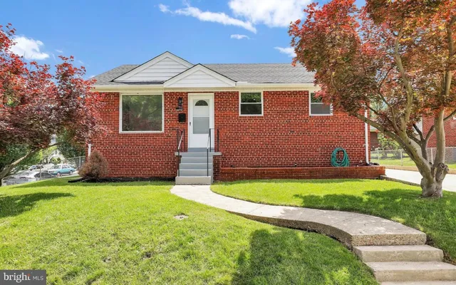 a front view of a house with a garden and yard