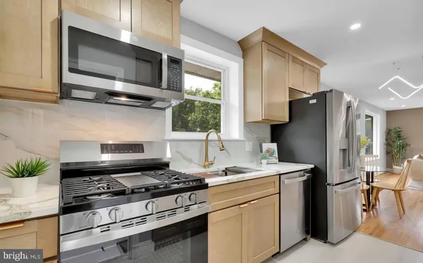 a kitchen with stainless steel appliances a stove a microwave and a refrigerator
