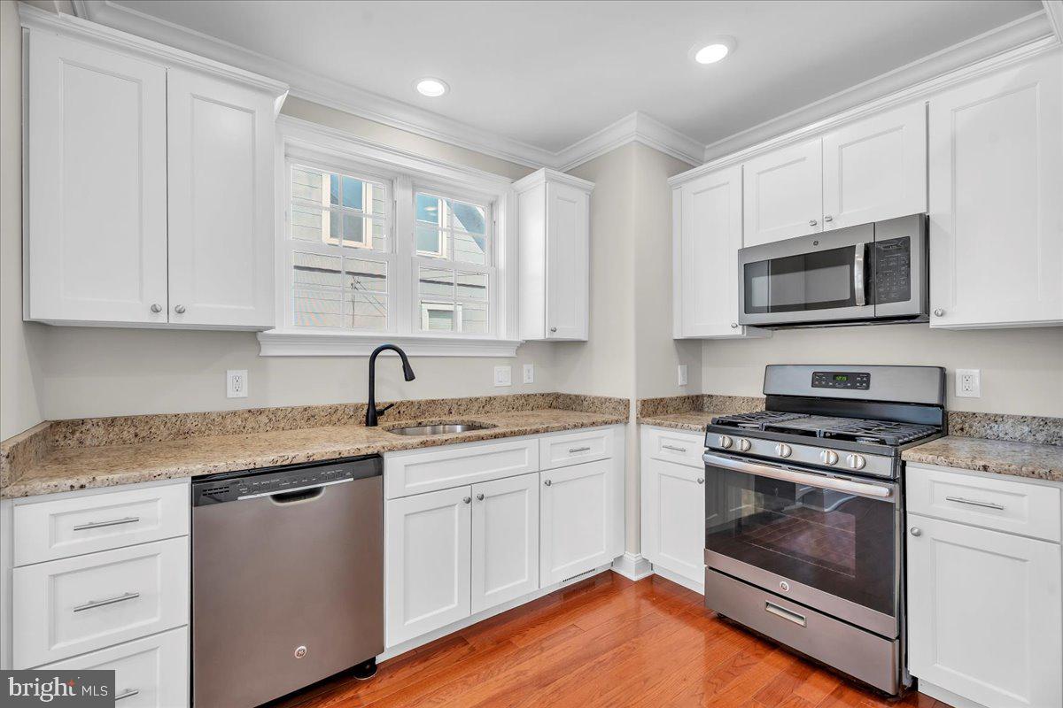 101 Center Avenue Mount Ephraim, NJ 08059 - Photo 15 of 42 a kitchen with cabinets stainless steel appliances a sink and wooden floor