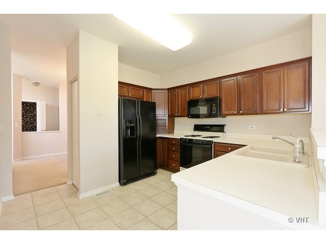 897 Havenshire Road, Unit 897 Naperville, IL 60565 - Photo 5 of 14 a kitchen with a refrigerator and a sink