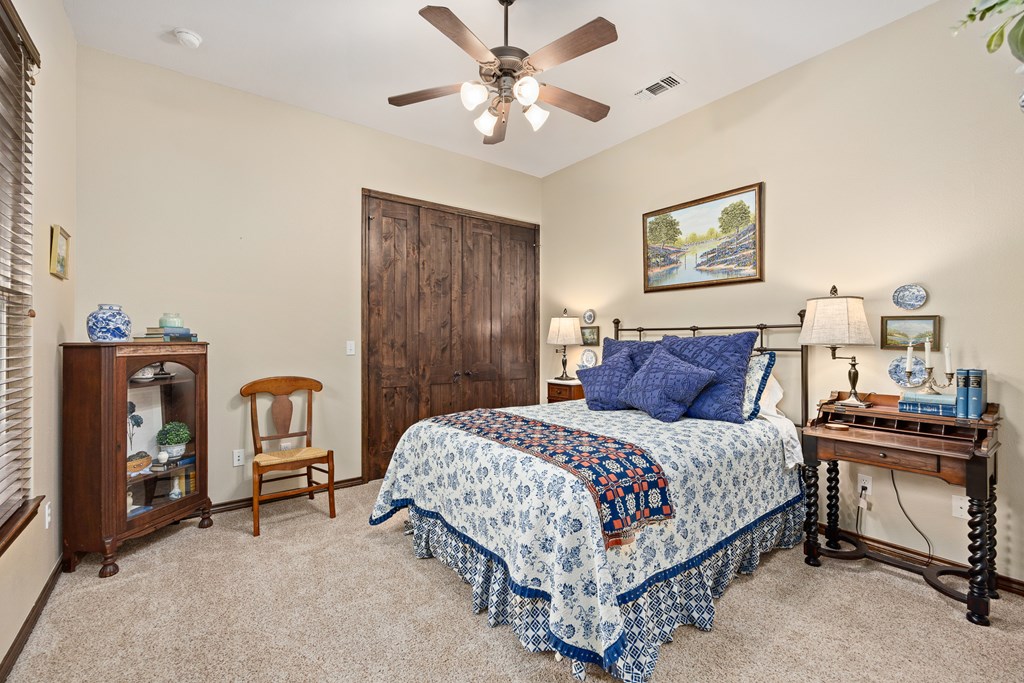 3801-16 Club House Road Kerrville, TX 78028 - Photo 13 of 22 a bedroom with a bed and a chandelier