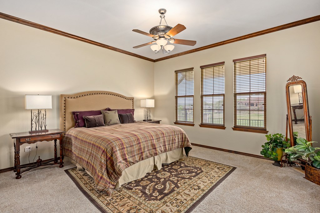 3801-16 Club House Road Kerrville, TX 78028 - Photo 10 of 22 a bedroom with a large bed and a chandelier