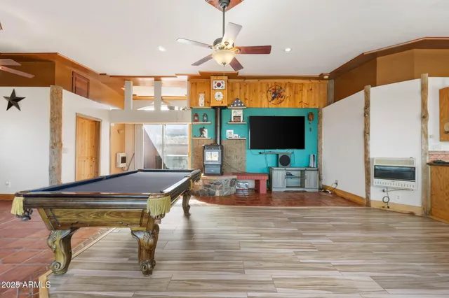 a living room with table chairs and a flat screen tv