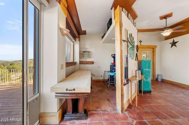 a living room with furniture a rug kitchen view and a large window