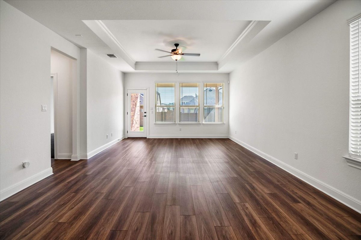 104 Raleigh Drive Georgetown, TX 78633 - Photo 4 of 37 Rich hardwood-style flooring extends through this airy living space with a classic tray ceiling and well-lit windows.