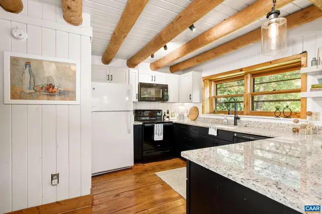 a kitchen with stainless steel appliances granite countertop a sink a stove and a wooden floors