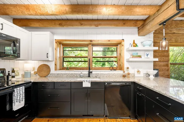 a kitchen with granite countertop a sink window and cabinets