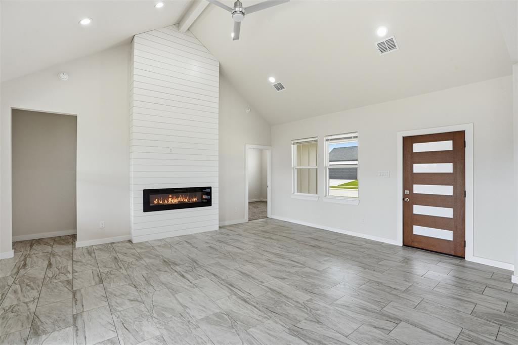 532 Highview Court Godley, TX 76044 - Photo 26 of 39 Vaulted ceilings over an open-concept living area with plank-style flooring