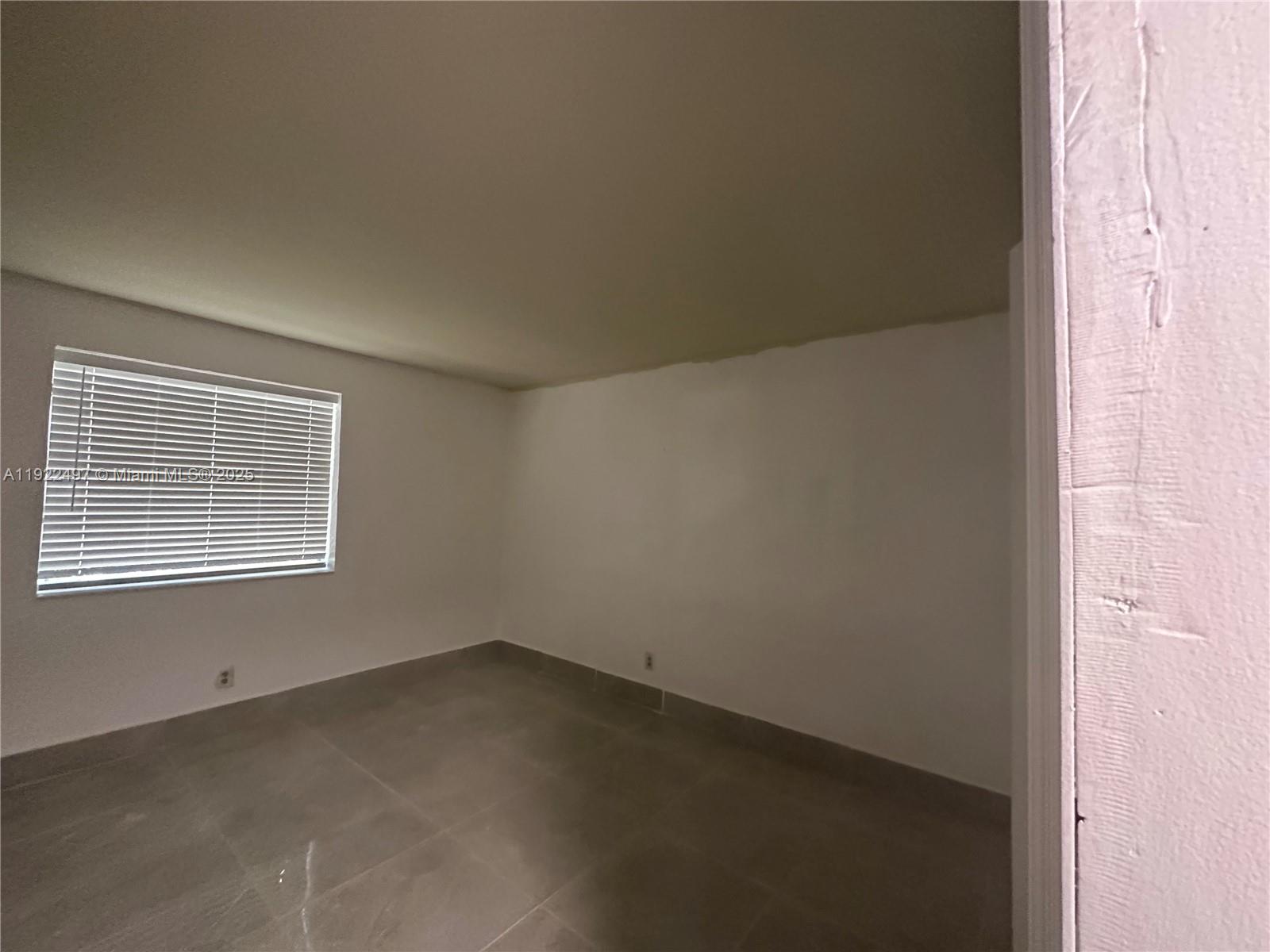 209 Southwest 5th Street Hallandale Beach, FL 33009 - Photo 3 of 5 an empty room with a window