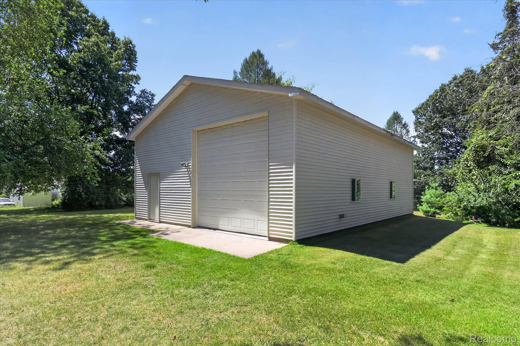 4037 Chilson Road Howell, MI 48843 - Photo 50 of 69 Detached outbuilding with a large garage door, a side entry door, and a concrete pad
