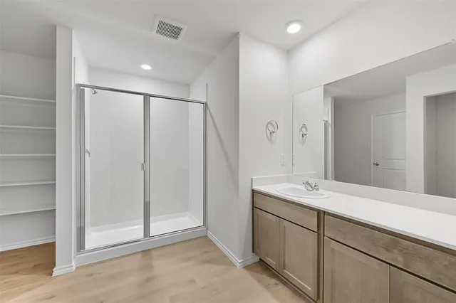 a spacious bathroom with a shower sink and mirror