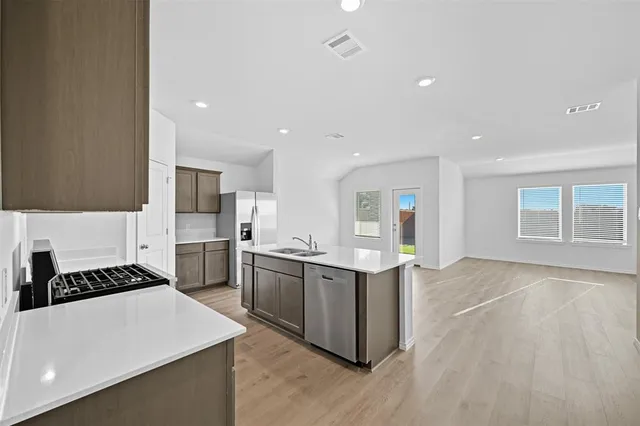 a kitchen with stainless steel appliances a sink and a stove top oven