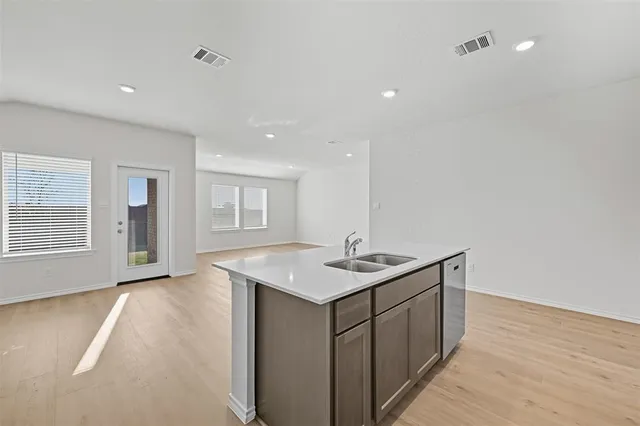 a kitchen with a sink a stove and wooden floor