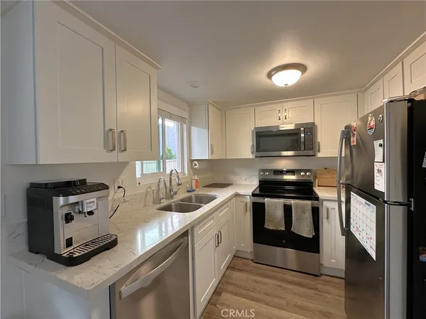a kitchen with stainless steel appliances granite countertop a stove a sink and a refrigerator