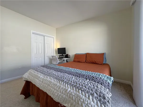 a bedroom with a bed and a view of kitchen