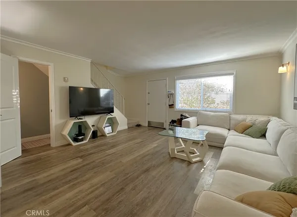 a living room with furniture a flat screen tv and a window