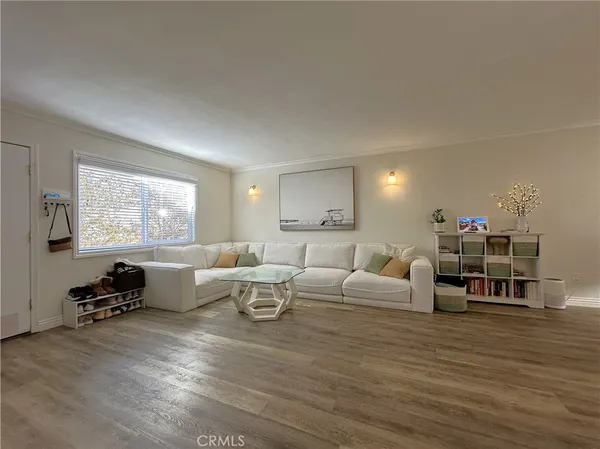 a living room with furniture a large window and a wooden floor