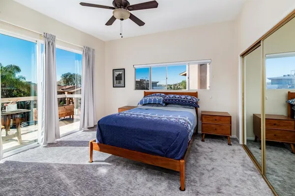 a bedroom with a bed and large windows