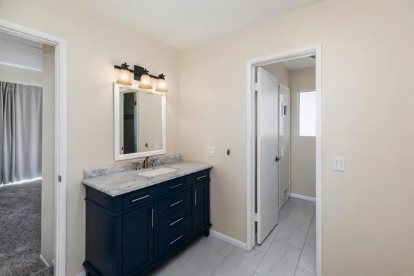a bathroom with a granite countertop sink and a mirror