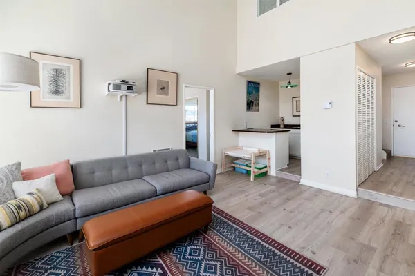 a living room with furniture and a dining table with wooden floor