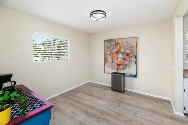a view of a kitchen with wooden floor and cabinets
