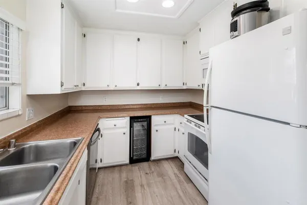 a kitchen with granite countertop white cabinets and a sink