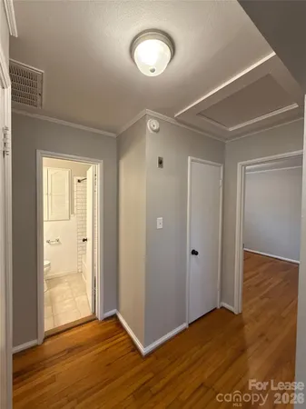 a view of an empty room with wooden floor