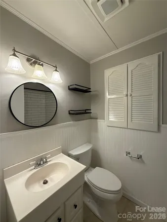 a bathroom with a sink a toilet and a mirror