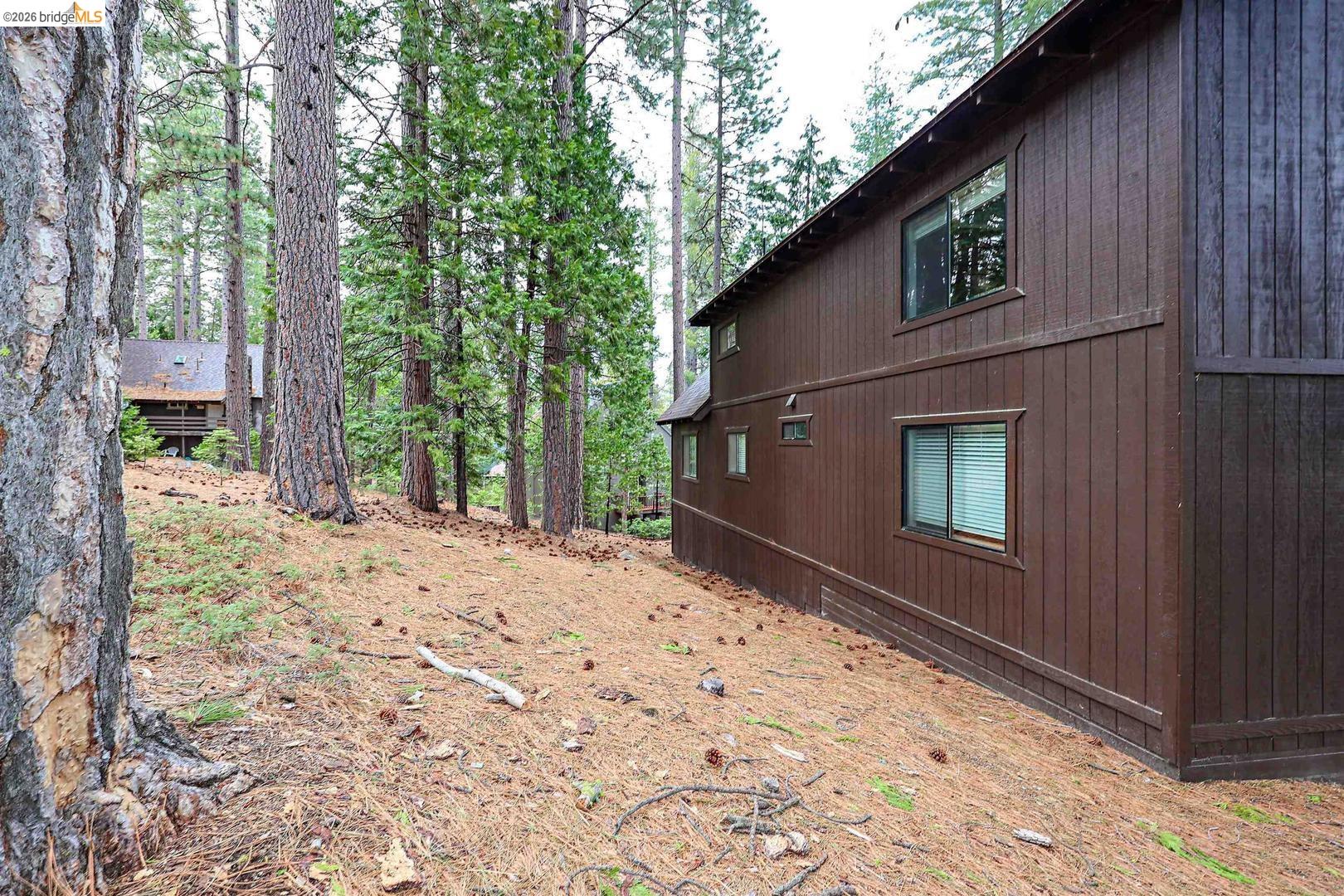 26600 Inyo Drive Cold Springs, CA 95335 - Photo 35 of 38 a backyard of a house with large trees and wooden fence